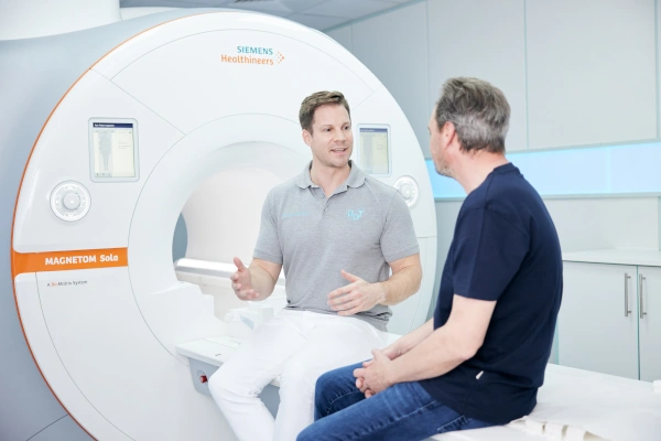 Arzt im Vorgespräch mit Patient vor dem MRT